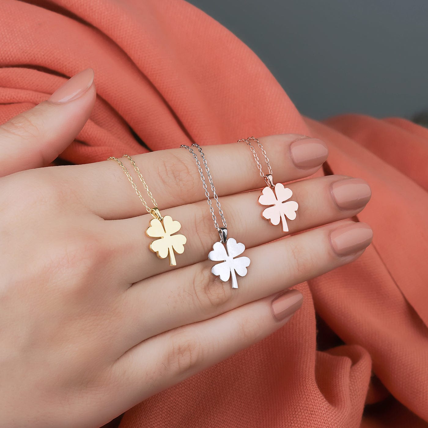 Kette mit kleeblatt gold in der hand